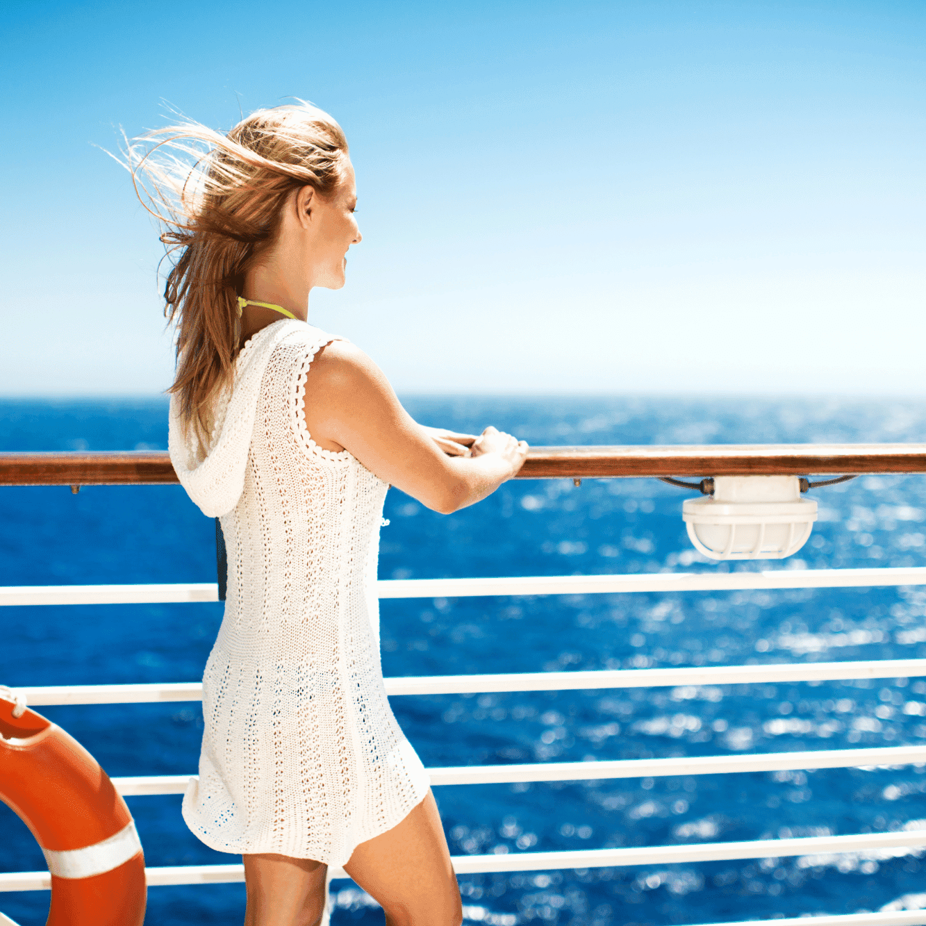 Woman in lightweight cover-up enjoying the ocean view, showcasing best clothing for cruise trips