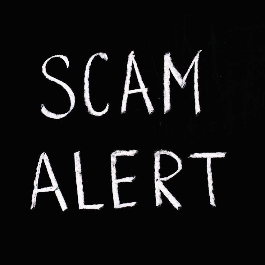 Scam alert warning written on a black background for how to spot travel scams