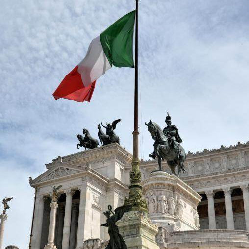 Italian flag flying over a historical monument in Rome, symbolizing quarantine-free flights to Italy 2023