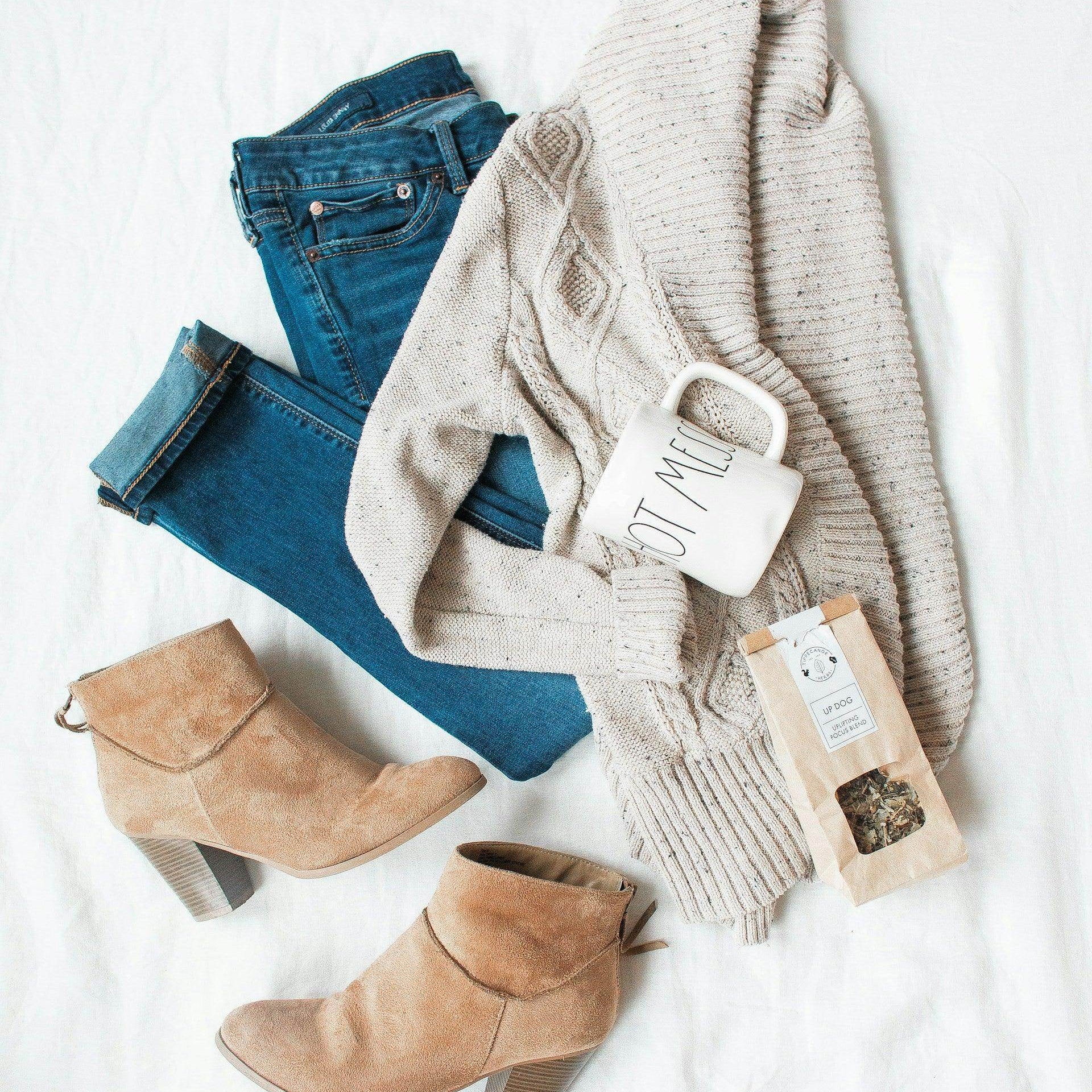 Versatile travel clothing featuring a cozy sweater, jeans, and stylish boots for vacation outfits