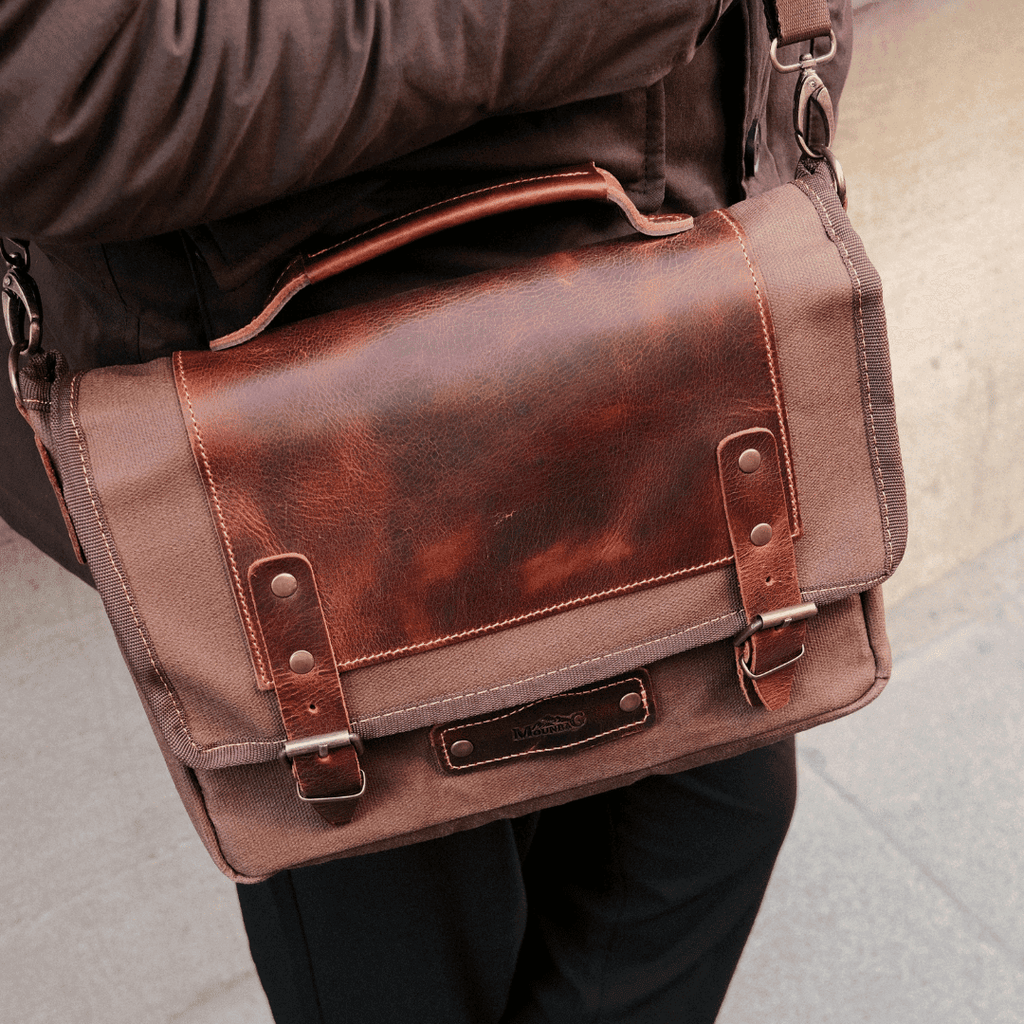 Stylish young man showcasing fashionable men's bags online in an urban setting