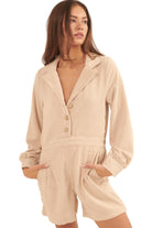 Beige corduroy romper for vacation featuring a collared neckline and button front with pockets