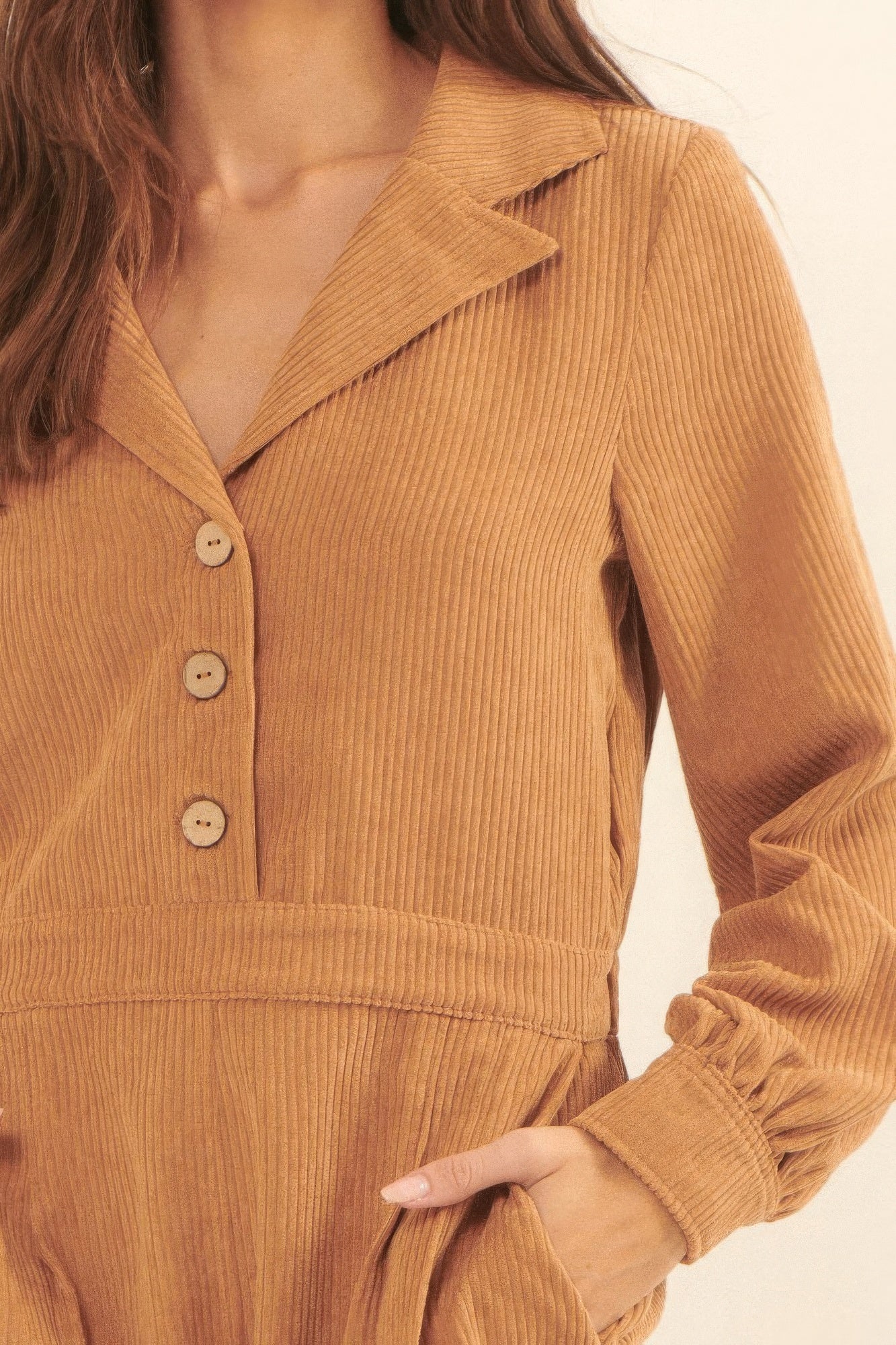 Brown corduroy romper for vacation featuring a collared neckline and button front