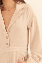 Beige corduroy romper for vacation featuring a collared neck and button details