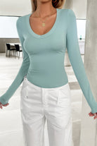 Light blue long sleeve shirt featuring a fitted design, ideal for layering with a white fitted v neck top for women.