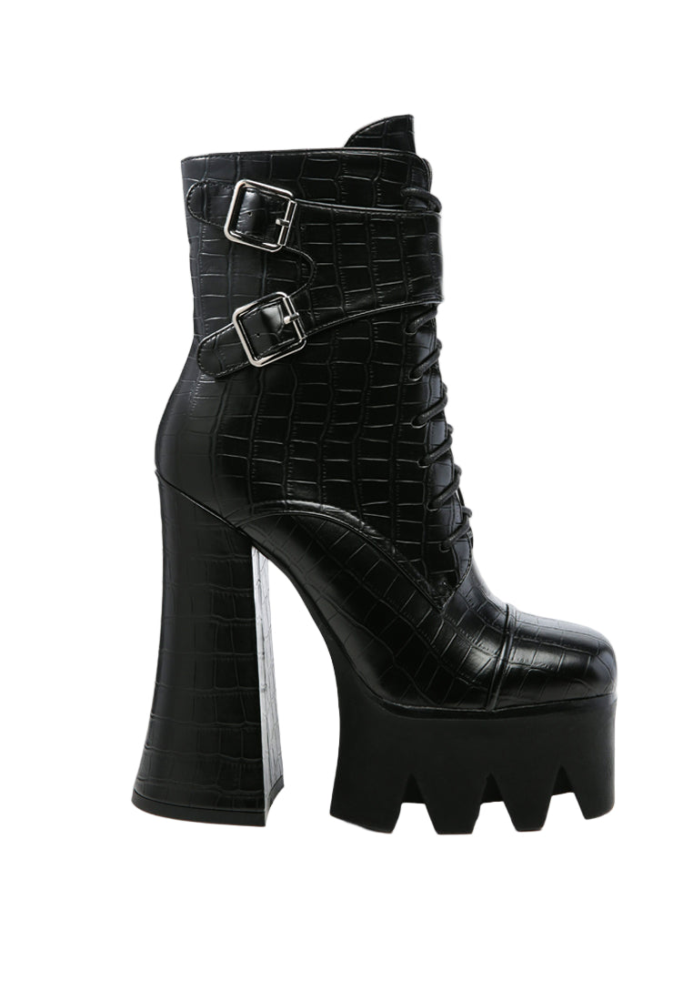 Black platform boots with high heels on a white background