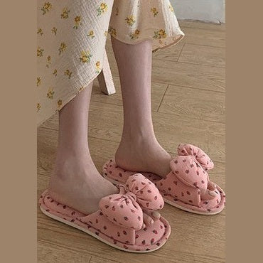 Miss Sparkling adorable plush bow slippers in pink with heart patterns on wooden floor