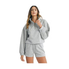 Woman wearing grey YNIQUE vacation athleisure wear for women with long sleeve half zip pullover and shorts