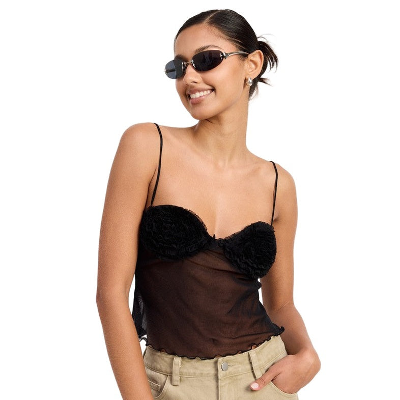 Model wearing Emory Park black sheer mesh floral cami top with floral bust cups spaghetti straps and khaki pants