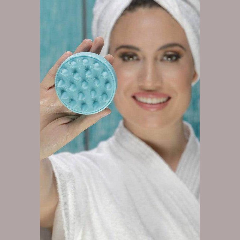 BeNat shower hair scalp scrubber in blue held by a woman in a bathrobe for effective hair care