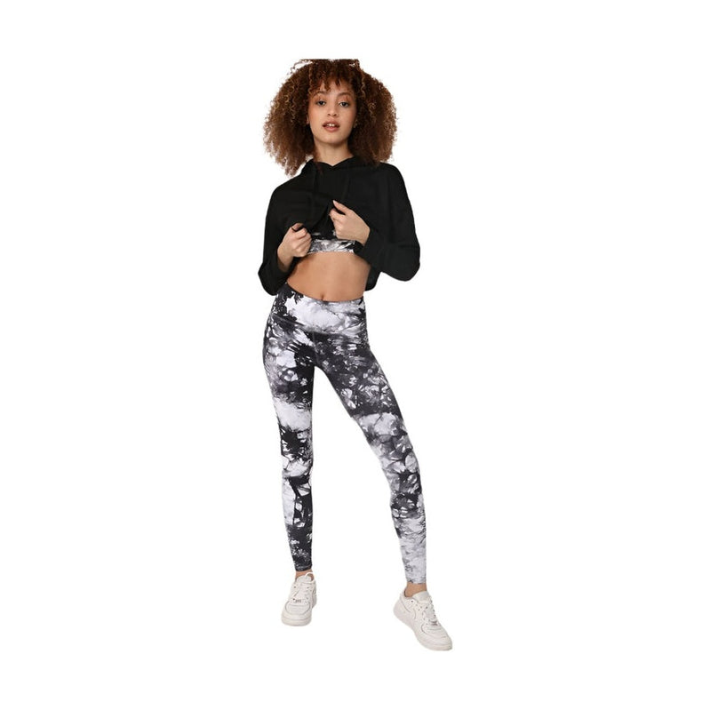 Woman wearing black and white tye dye yoga pants with a black cropped hoodie and white sneakers