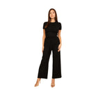 Woman wearing black casual travel outfit with short sleeve top and wide leg pants