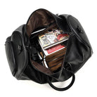Spacious black leather weekend bag opened with various items inside including books and a camera