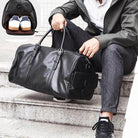 Black leather weekend bag with spacious interior for stylish travel and shoes compartment