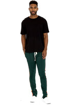 Man wearing WEIV casual rainbow tape sweatpants in green with side stripe and black t-shirt