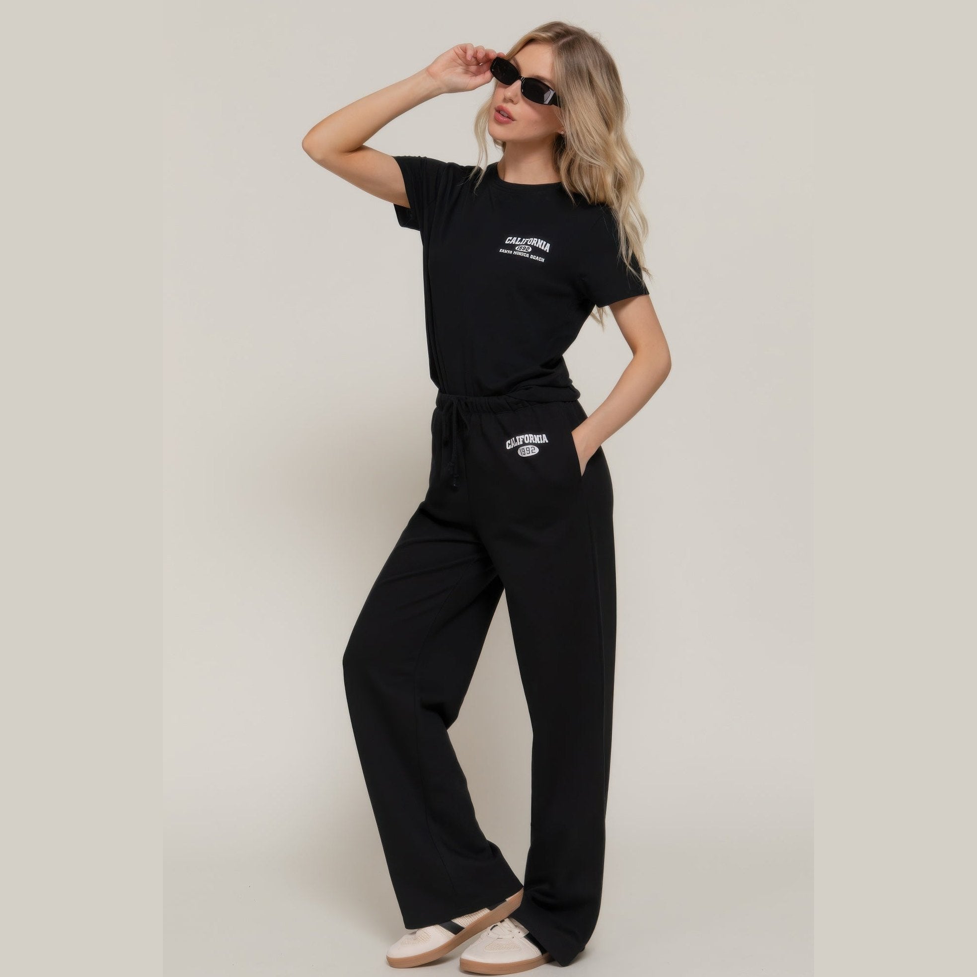 Women wearing black casual vacation lounge pants with matching black t-shirt and sunglasses