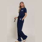 Woman wearing navy casual vacation lounge pants and matching t-shirt holding sunglasses