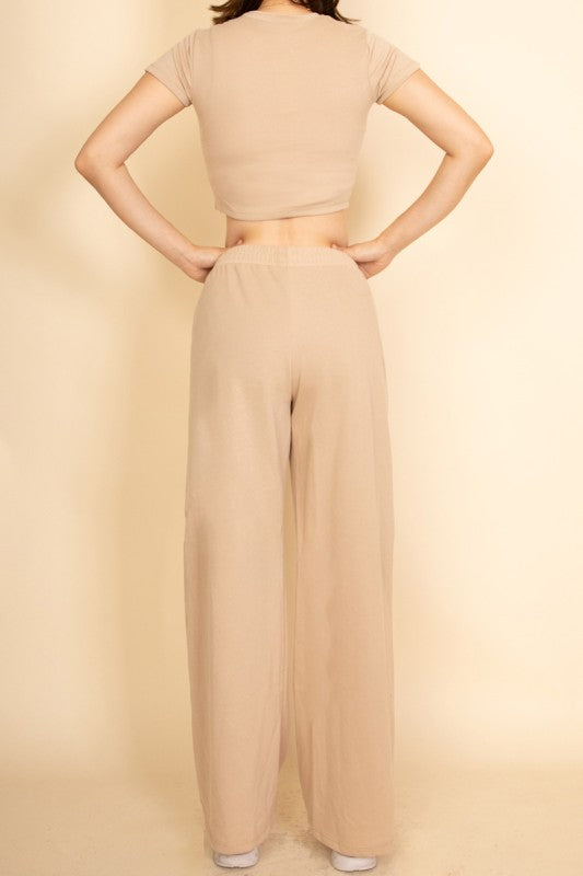 Model wearing beige casual wide-leg pants outfit with a matching cropped top from Capella