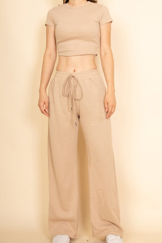 Woman wearing beige casual wide-leg pants outfit with drawstring waist and cropped t-shirt