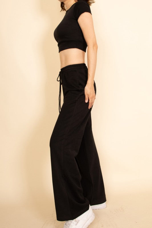 Capella black casual wide-leg pants outfit styled with a cropped black top and white sneakers