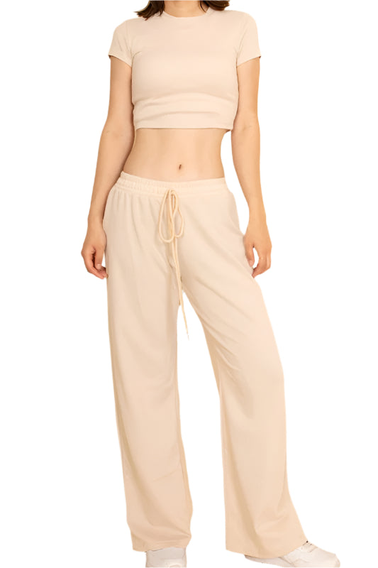 Woman wearing Capella casual wide-leg pants outfit with beige drawstring pants and a matching cropped top