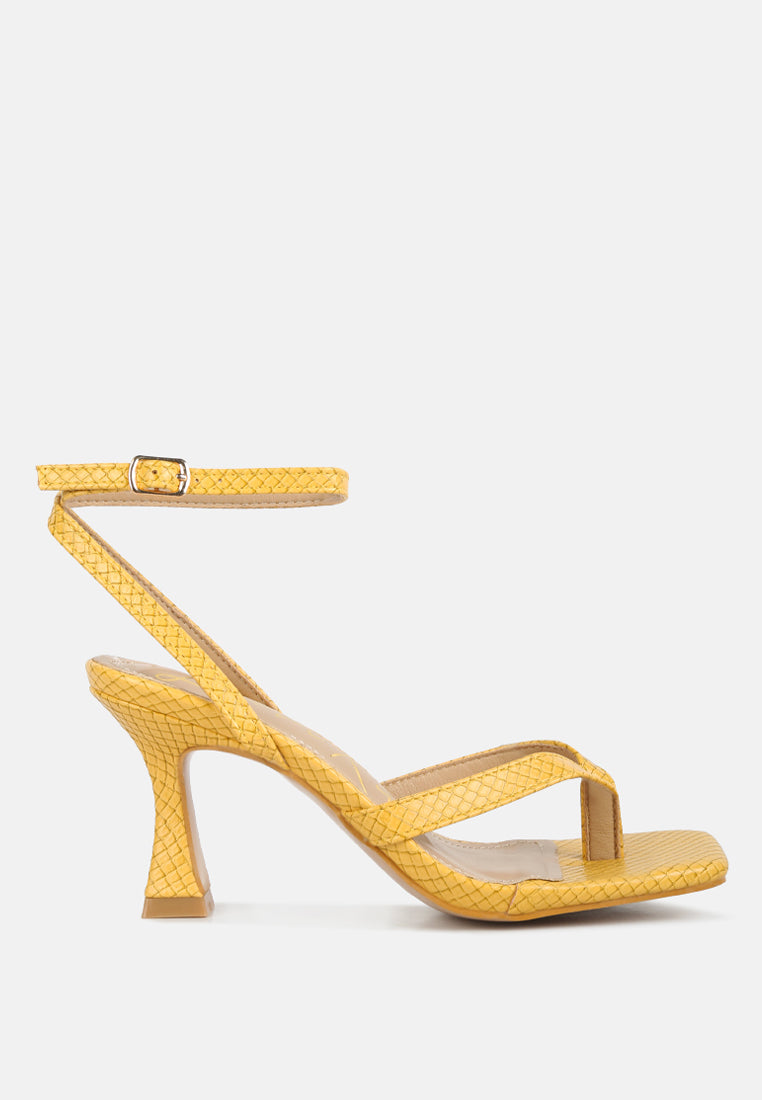 Yellow high-heeled sandal on a light gray background