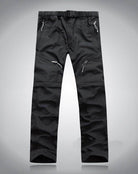 Men's black convertible pants for travel with multiple zippered pockets and adjustable belt