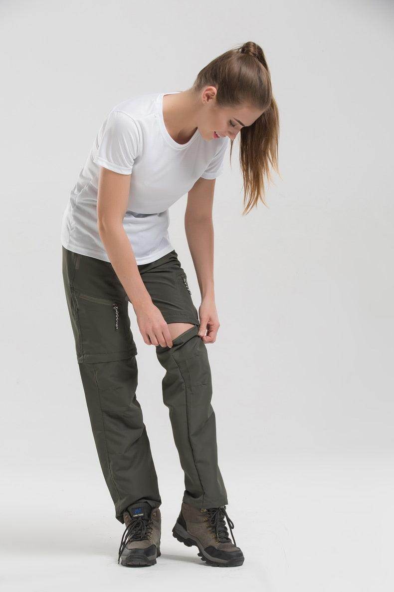 Woman adjusting VacationGrabs convertible pants for travel in olive green color, perfect for outdoor adventures