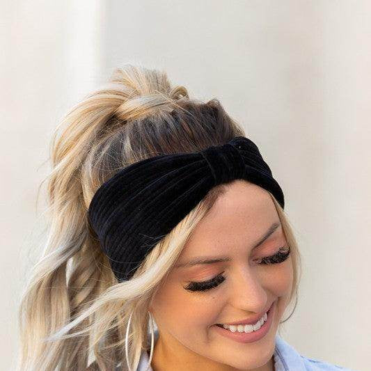 Aili's Corner corduroy hair wrap in black, stylishly worn by a smiling woman with a ponytail