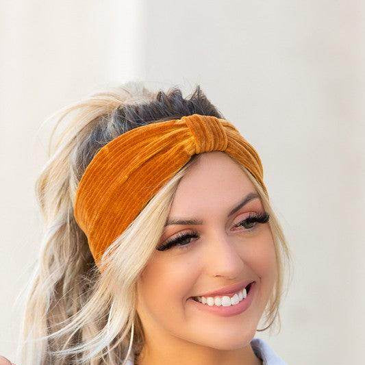 Aili's Corner corduroy hair wrap in rich orange color worn by a smiling woman with blonde hair