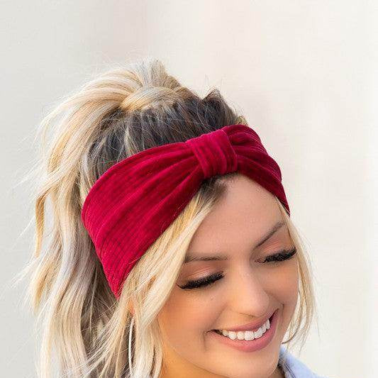 Aili's Corner red corduroy hair wrap with a stylish bow design on a smiling woman