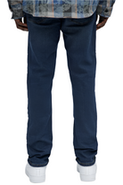 Dark wash urban jeans men by VacationGrabs shown from the back on a model wearing white sneakers