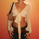 Womens cropped tie front top in beige with long sleeves styled with belt and bag
