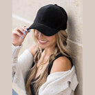 Aili's Corner designer velour caps in black, styled with casual attire for a chic look