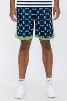 Double O Tape casual sweat shorts in navy with white logo print and green trim worn with white sneakers