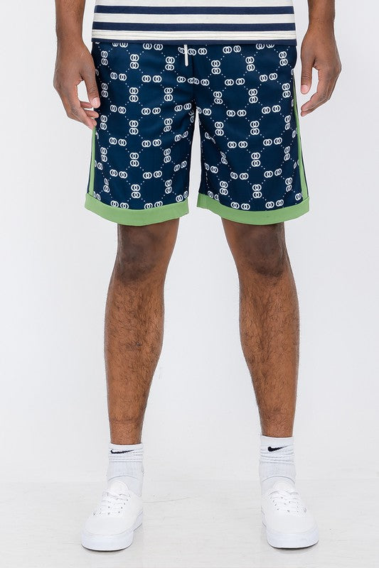 Double O Tape casual sweat shorts in navy with white logo print and green trim worn with white sneakers