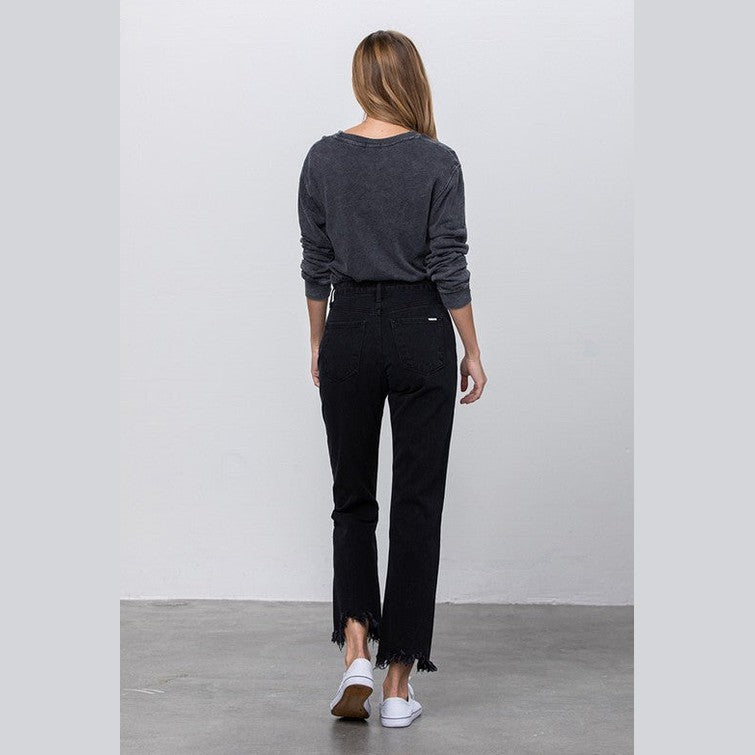 Women's edgy straight leg jeans in black with frayed hem, showcased from the back