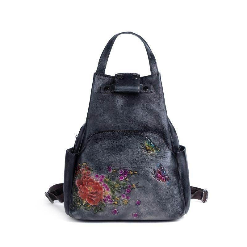 Embossed leather travel bag with floral design and colorful butterfly accents for stylish journeys