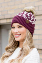 Aili's Corner fashionable animal print beanie in maroon with a faux fur pom pom for stylish winter wear