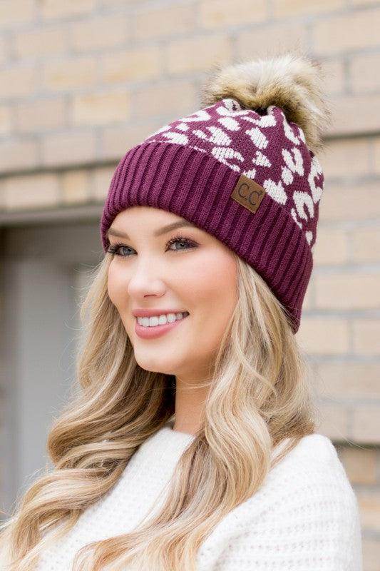 Aili's Corner fashionable animal print beanie in maroon with a faux fur pom pom for stylish winter wear