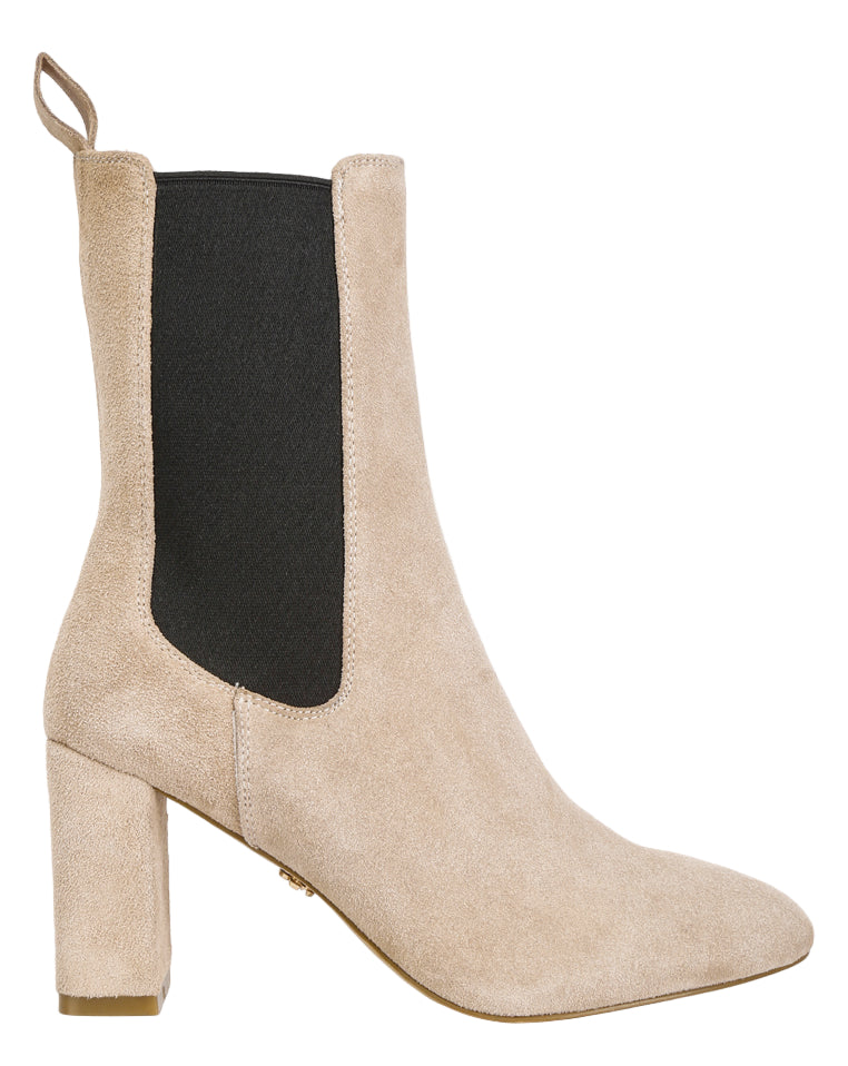 Beige ankle boot with a black side panel on a light gray background
