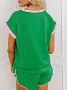 Model wearing green two tone tee and shorts set with pink trim from EG fashion, back view