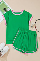Green two tone tee and shorts set with pink trim by EG fashion laid flat with sports accessories