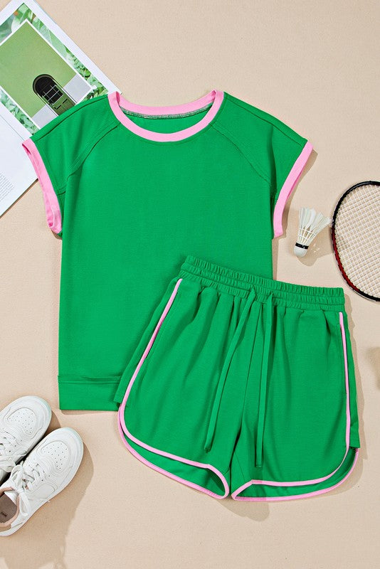 Green two tone tee and shorts set with pink trim by EG fashion laid flat with sports accessories