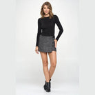 Miley + Molly grey mini wrap skirt styled with a fitted black top and ankle boots