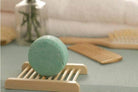 BeNat handcrafted shampoo bar displayed on a wooden holder surrounded by hair care accessories