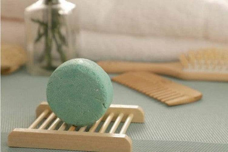 BeNat handcrafted shampoo bar displayed on a wooden holder surrounded by hair care accessories