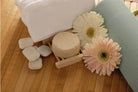 BeNat handcrafted shampoo bar surrounded by towels and flowers on a bamboo mat
