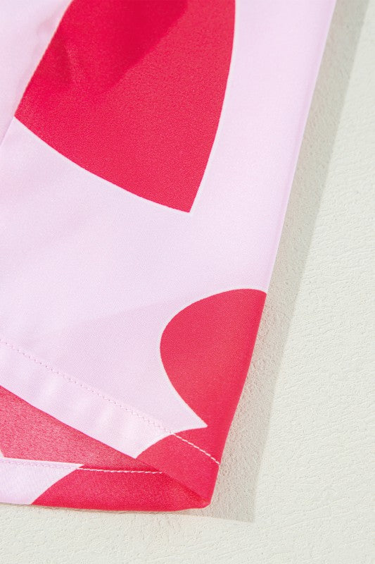 Close-up detail of YNIQUE heart print valentine pajamas set featuring red heart patterns on pink fabric
