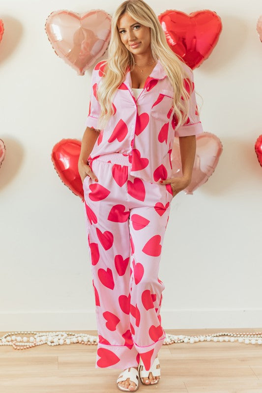 YNIQUE heart print valentine pajamas set with pink fabric and red hearts worn by a woman with long blonde hair